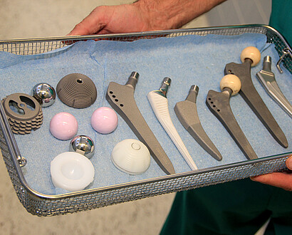 Willibrord-Spital-EPZ-Arzt haelt-Korb-mit-verschiedenen-Hueftprothesen